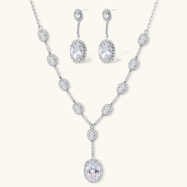Elegant white gold plated jewelry set with oval cubic zirconia stones in halo settings, featuring Y-necklace and drop earrings.