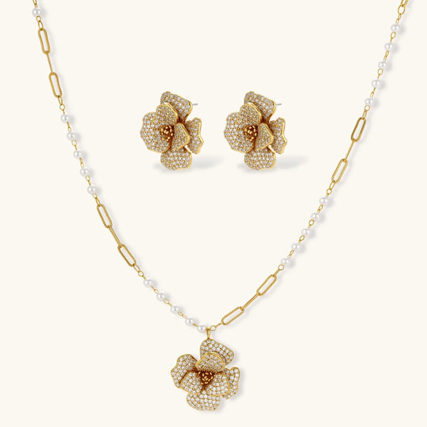 14K gold-plated floral jewelry set with blue cubic zirconia centers and pearl chain details on white background.