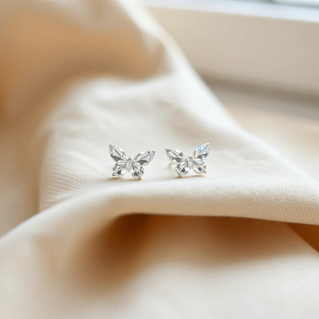 Crystal butterfly stud earrings with subtle sparkle on a neutral fabric background