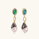 Gold drop earrings with iridescent abalone studs, rope links, jeweled caps and white baroque pearls on cream background