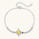 Sterling silver bracelet with yellow moissanite centerpiece in oval setting, crystal chain, and star charm on white background.