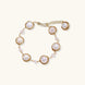 Gold wire-wrapped freshwater pearl bracelet with alternating pearl sizes on cream background, adjustable length