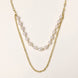 Layered gold chain necklace with organic baroque freshwater pearls and adjustable length on cream background
