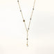 Y-shaped gold-plated necklace with white and gray freshwater pearls on cream background, showing adjustable drop design.