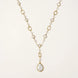 Long gold-plated necklace with alternating freshwater pearls and crystal bezels, featuring a large baroque pearl pendant