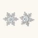 Sterling silver snowflake stud earrings with brilliant moissanite centers and intricate geometric patterns on cream background