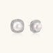 Rhodium-plated sterling silver stud earrings with round freshwater pearls surrounded by geometric crystal halos on cream background.