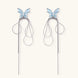 Long silver-tone earrings with powder blue enamel butterfly studs and flowing chain tassels on cream background