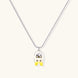 Chrome egg-shaped pendant with kawaii face, yellow bow, and pearl detail on silver chain against white background