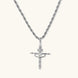 Silver-tone necklace with dimensional orb pendant, cross crown detail, and zirconia stones on twisted rope chain