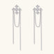 White gold plated baroque cross stud earrings with long cascading zirconia chains on cream background