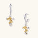 Two-tone huggie hoops with gold rose crosses and star zirconia accents on cream background