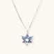 White gold-plated lotus pendant with blue denim fabric inlay and sparkling zirconia stones on adjustable chain