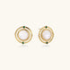 Circular gold stud earrings with iridescent mother-of-pearl center and green zirconia accents on cream background.