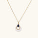 Gold necklace with navy lapis lazuli stone and iridescent mother-of-pearl teardrop pendant with crystal accents
