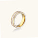 14K gold-plated ring with dual rows of clear baguette and round zirconia stones on cream background.