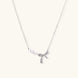Delicate white gold plated necklace with freshwater pearls and sparkly crystal bow pendant on white background