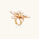 Gold-plated sculptural ring featuring white enamel petals forming an oversized lily bloom on adjustable band